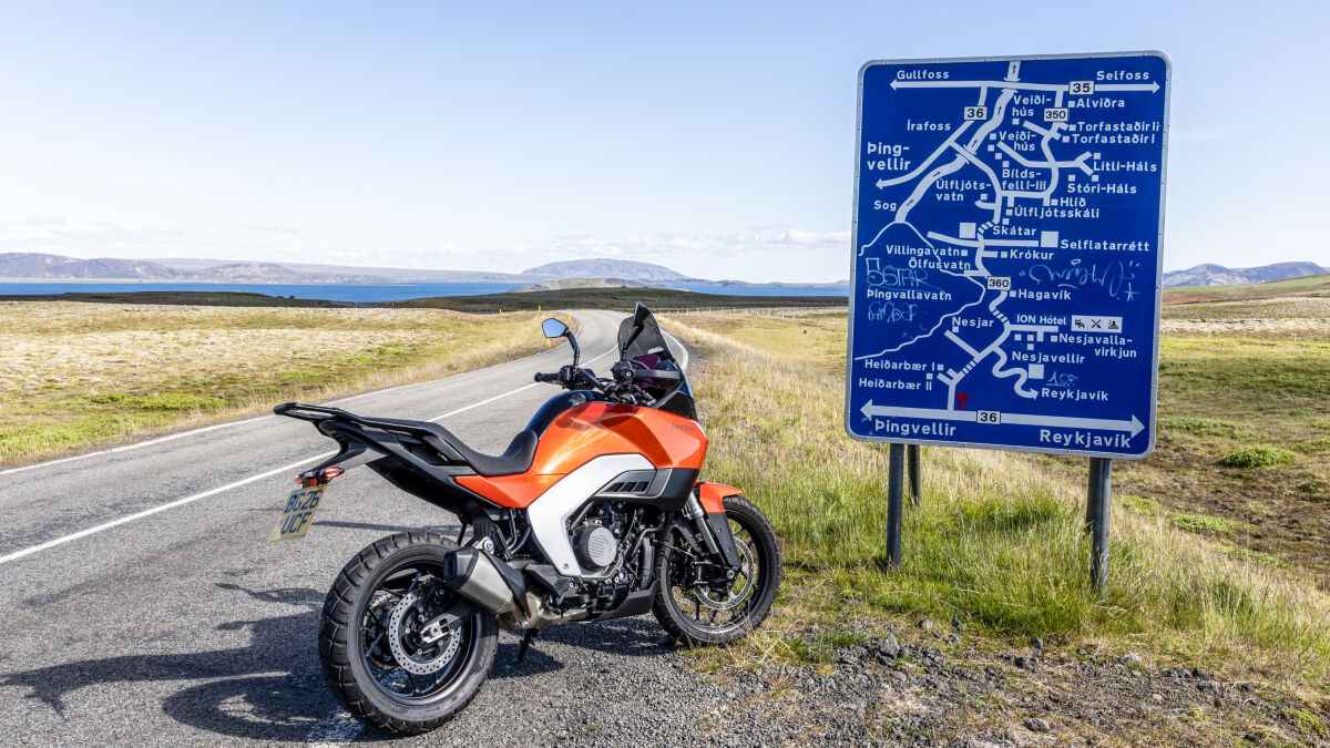Grüne Moosflächen, graue Felsen, blaues Meer (und Schilder) – und dazu die auffällig orangefarben lackierte Norton Atlas: Rein farblich haben die Briten schon mal alles richtig gemacht beim ersten offiziellen Presse-Testride ihrer neuen Zweizylinder-Reiseenduro